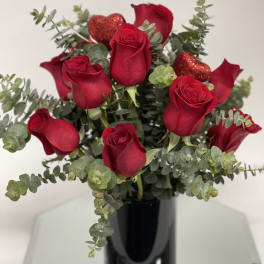 Red roses with eucalyptus in a black vase