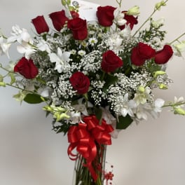 Bouquet of red roses and white orchids with a red bow