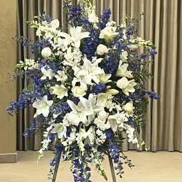 Large white and blue floral standing spray on an easel