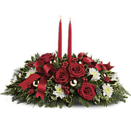 Red rose centerpiece with two red candles and holiday ribbon