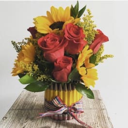 Bouquet of red roses and yellow sunflowers in a pencil vase