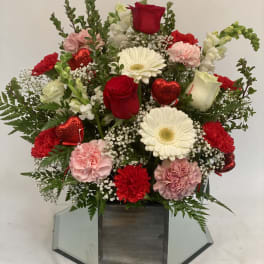 Mixed bouquet of red and white flowers in a wooden box with red heart picks