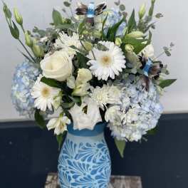 Blue and white floral arrangement in a patterned vase