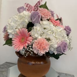 Pink and lavender bouquet with hydrangeas, roses, and gerbera daisies in a brown vase