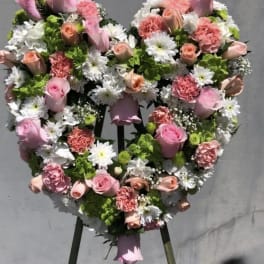 Heart-shaped floral wreath with pink roses and white daisies