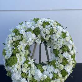 Large white and green floral wreath on an easel