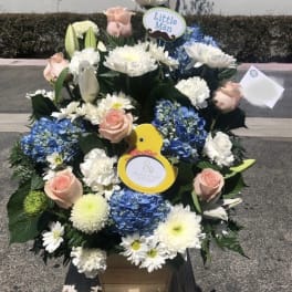 Large floral arrangement with blue hydrangeas, white daisies, and pale pink roses