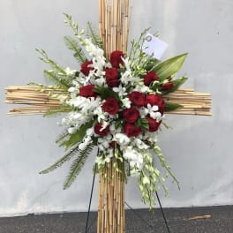 Red roses and white orchids arranged on a bamboo cross