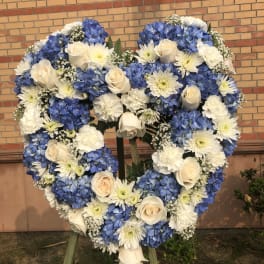 Heart-shaped floral wreath with blue hydrangeas, white roses, and white daisies