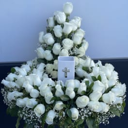 Large white rose funeral spray with a cross ornament