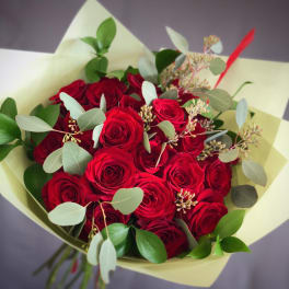 Bouquet of red roses with eucalyptus in pale wrapping