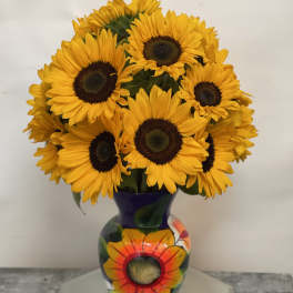 Bouquet of yellow sunflowers in a painted purple vase