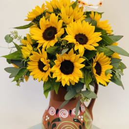 Sunflower bouquet in a painted ceramic pitcher