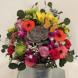 Mixed bouquet in a metal vase with a butterfly accent