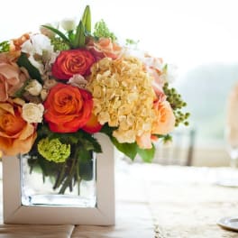 Mixed bouquet of roses and hydrangeas in a square glass vase