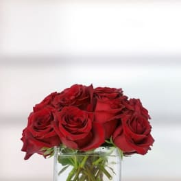 Red roses arranged in a clear glass vase