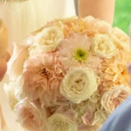 Bride holding a pale peach and cream bouquet