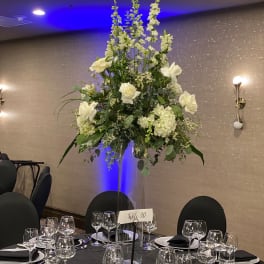 Tall white floral centerpiece on a banquet table