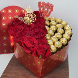 Heart-shaped box with red roses and gold-wrapped chocolates
