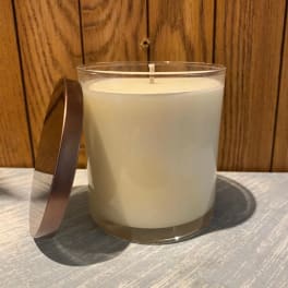 White candle in a clear glass jar with a metal lid
