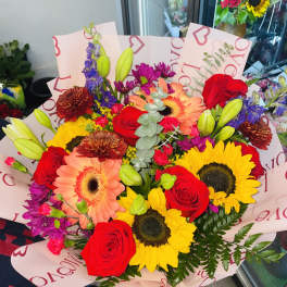 Mixed bouquet of red roses, sunflowers, and pink gerbera daisies