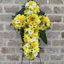 Yellow and white floral cross on a stand