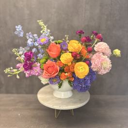 Colorful mixed bouquet in a white pedestal vase