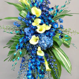 Tall blue and yellow floral standing arrangement with calla lilies