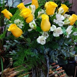 Yellow roses and white alstroemeria in a ribbed glass vase