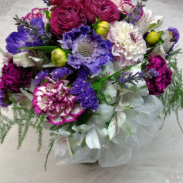 Bouquet of purple, pink, and white flowers wrapped in sheer fabric