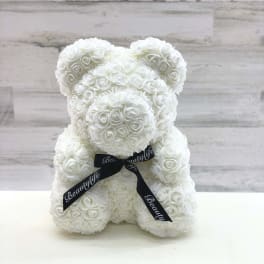 White rose teddy bear with a black ribbon bow