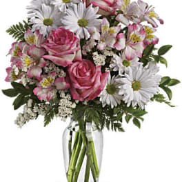 Pink roses and white daisies in a clear glass vase