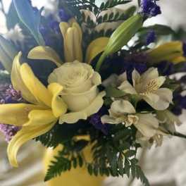 Bouquet of yellow lilies, white roses, and white alstroemeria with purple accents