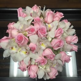 Pink roses and white orchids arranged in a bouquet