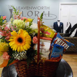 Basket arrangement with yellow flowers and snack bags