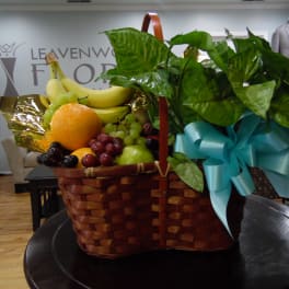 Fruit basket with bananas, grapes, oranges, and a blue ribbon