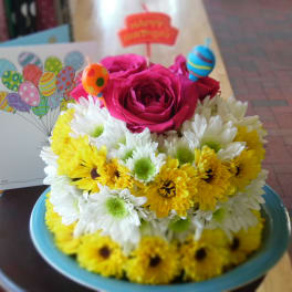 Pink roses and yellow-white daisies in a blue bowl with balloon picks