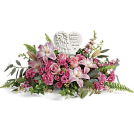 Pink lilies and roses arranged around a memorial heart plaque