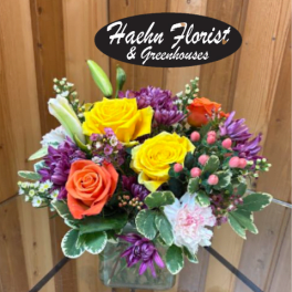Mixed bouquet of yellow and orange roses in a glass vase
