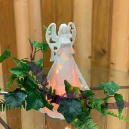 White angel figurine with glowing light and ivy garland