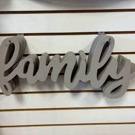 Gray layered wooden "family" wall sign on a slatwall display