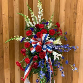 Tall red, white, and blue floral standing spray with ribbon