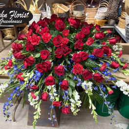 Large red rose arrangement with blue and white flowers in a store display