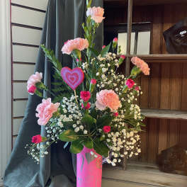 Pink carnations and baby's breath in a pink heart vase