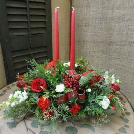 Red and white floral centerpiece with two tall red candles