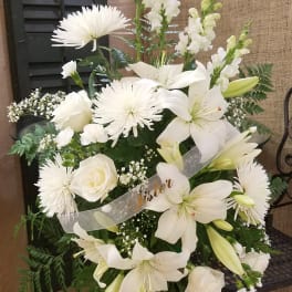 White lilies and roses in a standing sympathy spray