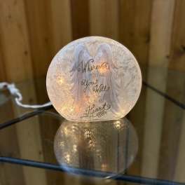 Glowing memorial light with angel wings and a sympathy message