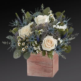 White roses and blue thistle in a pink wooden box