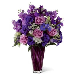 Purple and pink mixed bouquet in a tall glass vase
