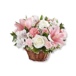 Pink and white flower arrangement in a wicker basket